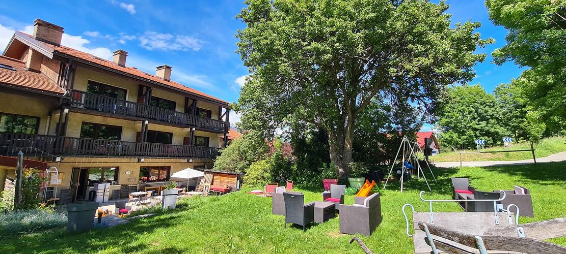 Cocktail servi en terrasse dans le jardin arboré de L’Adray