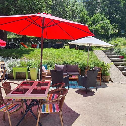 Terrasse du restaurant L’Adray avec vue sur le jardin arboré